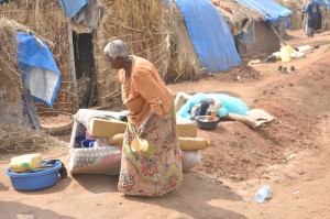 AN OLD WOMAN GATHERING HER BELONGINGS TO LEAVE