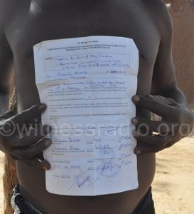 Mulenje Phillipo displaying a forced sell agreement that took his 100 acres